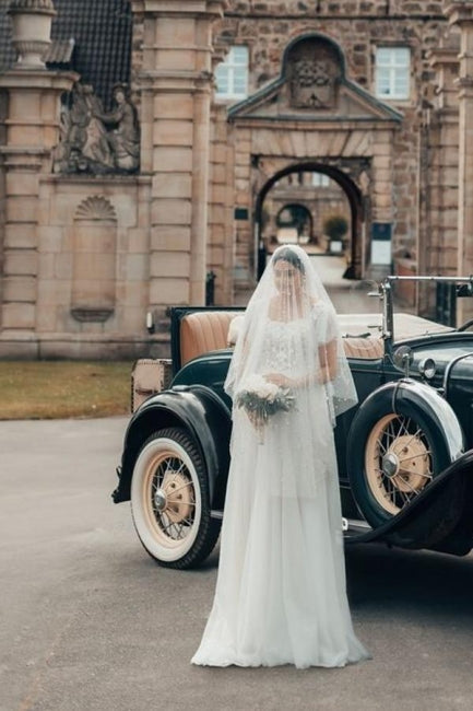 Robe de mariée élégante longue blanche en tulle et dentelle, coupe trapèze, col carré, manches courtes