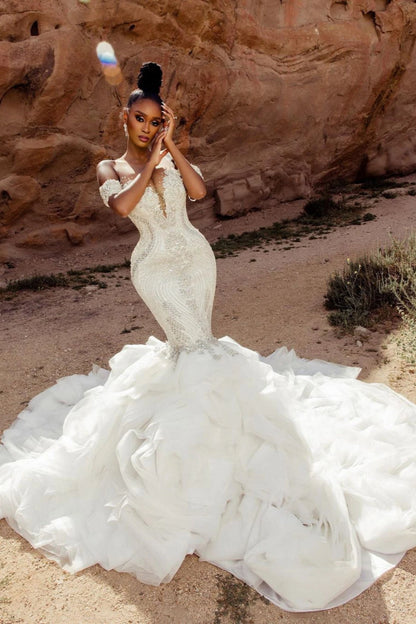 Elegante vestido de novia blanco sin mangas con hombros descubiertos y encaje de sirena con cuentas