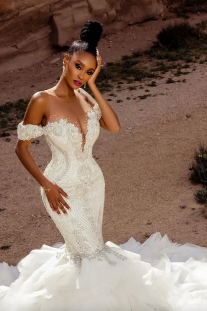 Elegante vestido de novia blanco sin mangas con hombros descubiertos y encaje de sirena con cuentas