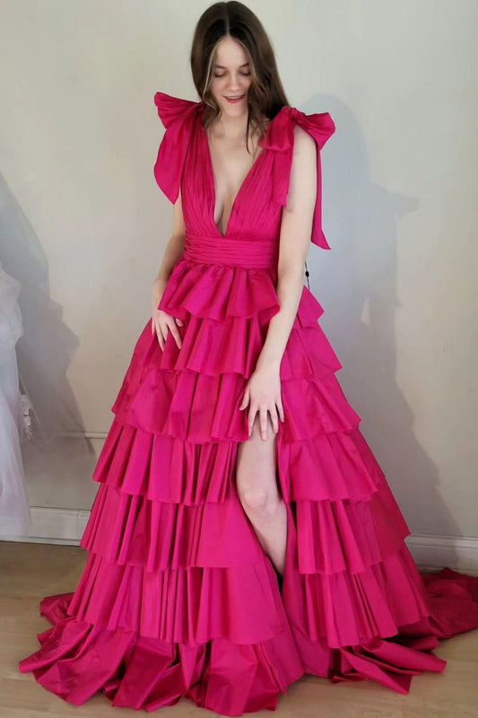 Vestido de gala fucsia con escote en V pronunciado, tirantes con lazo y volantes