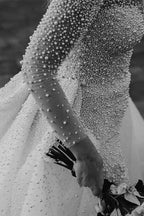 Elfenbeinfarbenes Brautkleid mit langen Ärmeln, Schleppe, V-Ausschnitt und Knöpfen und vollständig mit Perlen besetzt 