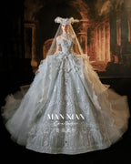 Abito da sposa celeste con perline, scollo a spalle scoperte, gonna a palloncino, strascico a cattedrale e motivi lunari