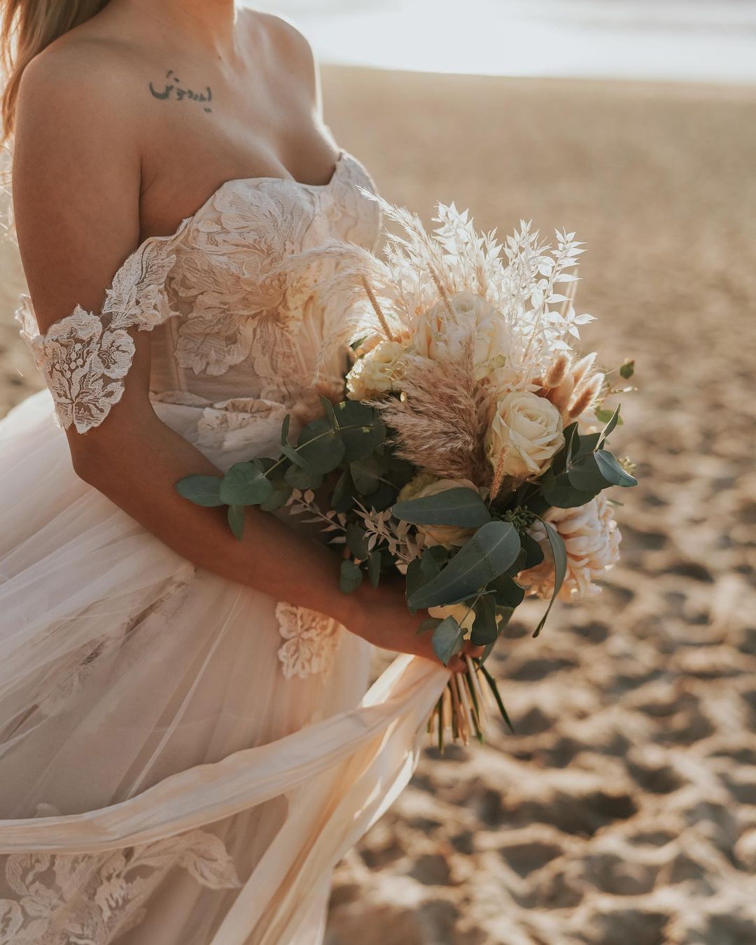 Robe de mariée longue en tulle avec dentelle appliquée, décolleté bardot et dos nu, coupe évasée