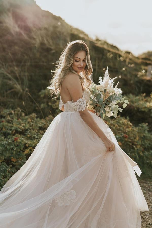 Robe de mariée longue en tulle avec dentelle appliquée, décolleté bardot et dos nu, coupe évasée