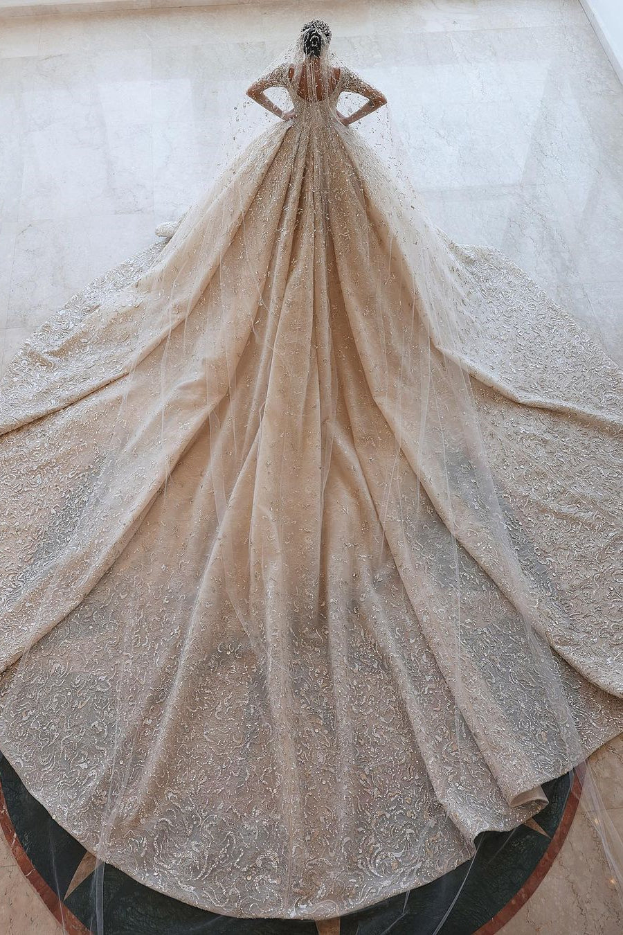 Robe de mariée luxueuse en dentelle à manches longues et coupe en A avec traîne