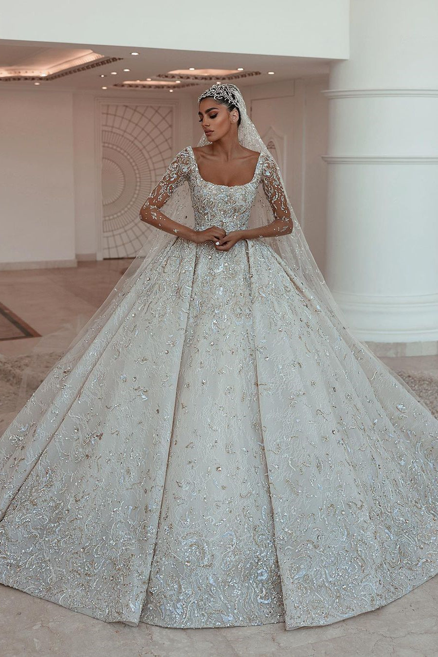 Robe de mariée luxueuse en dentelle à manches longues et coupe en A avec traîne