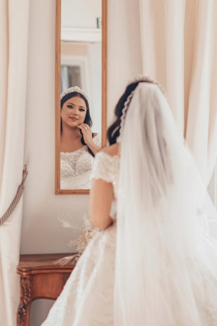 Lujoso vestido de novia blanco largo de satén con hombros descubiertos y encaje.