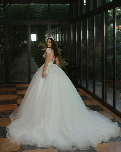 Luxuriöses langes A-Linien-Brautkleid mit V-Ausschnitt, Perlen, Tüll und Glitzer und Flügelärmeln