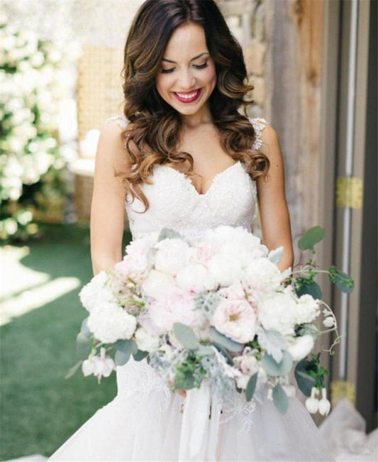 Vestido de novia de tul color marfil con cola de sirena y escote barco 