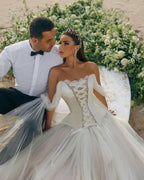 Vestido de novia moderno de tul con corsé, largo, sin mangas y hombros descubiertos.