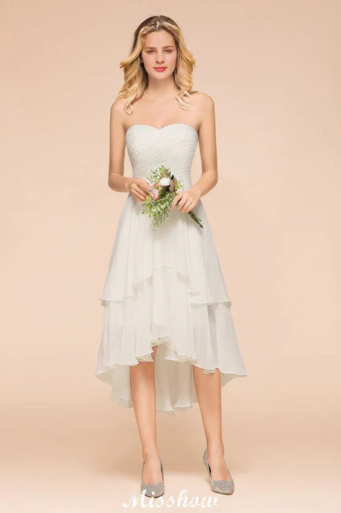 Abito da damigella d'onore romantico bianco/avorio con scollo a cuore e orlo asimmetrico, senza maniche, per matrimonio in spiaggia