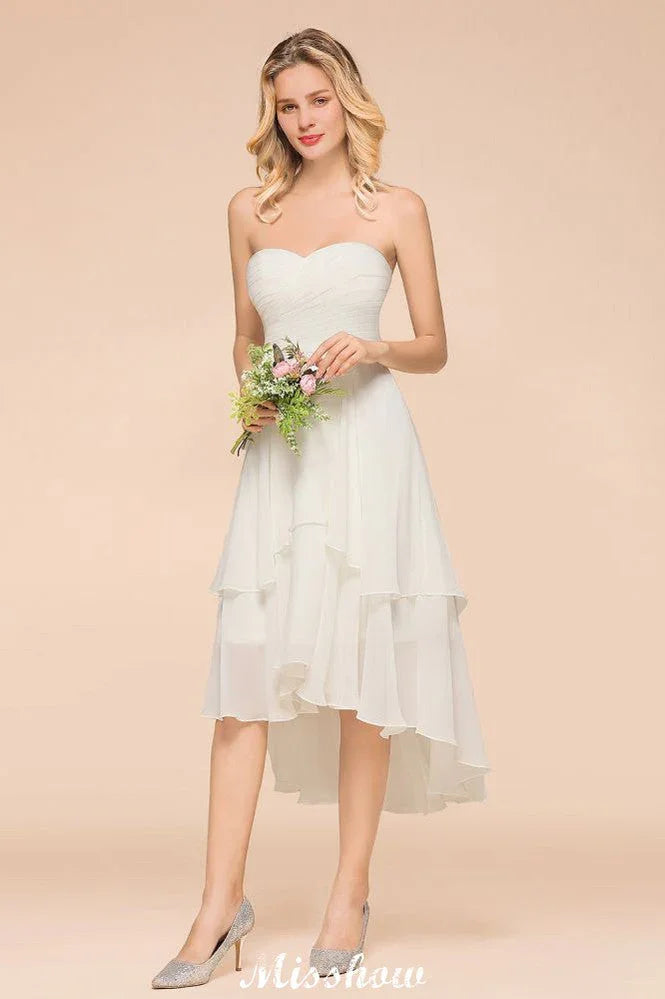 Abito da damigella d'onore romantico bianco/avorio con scollo a cuore e orlo asimmetrico, senza maniche, per matrimonio in spiaggia