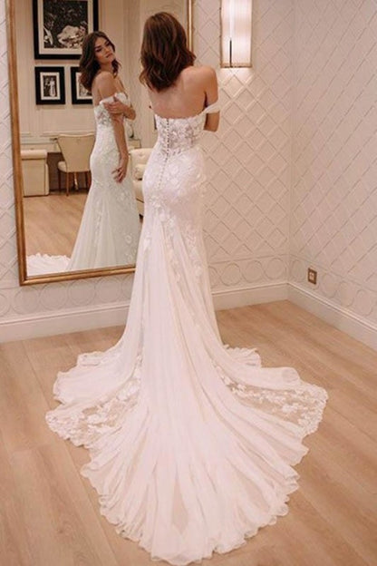 Vestido de novia elegante color marfil con apliques y hombros descubiertos, estilo playero y cola de corte.