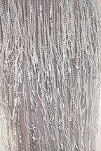 فستان سهرة برقبة على شكل حرف V مزين بشراريب وذيل حورية البحر ومرصع بالترتر