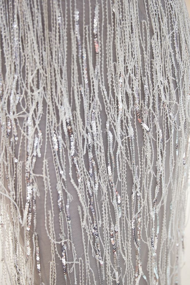 فستان سهرة برقبة على شكل حرف V مزين بشراريب وذيل حورية البحر ومرصع بالترتر