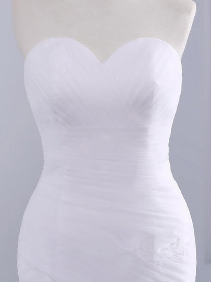 Vestido de novia de sirena sin tirantes con escote corazón y encaje de tul sin volantes.